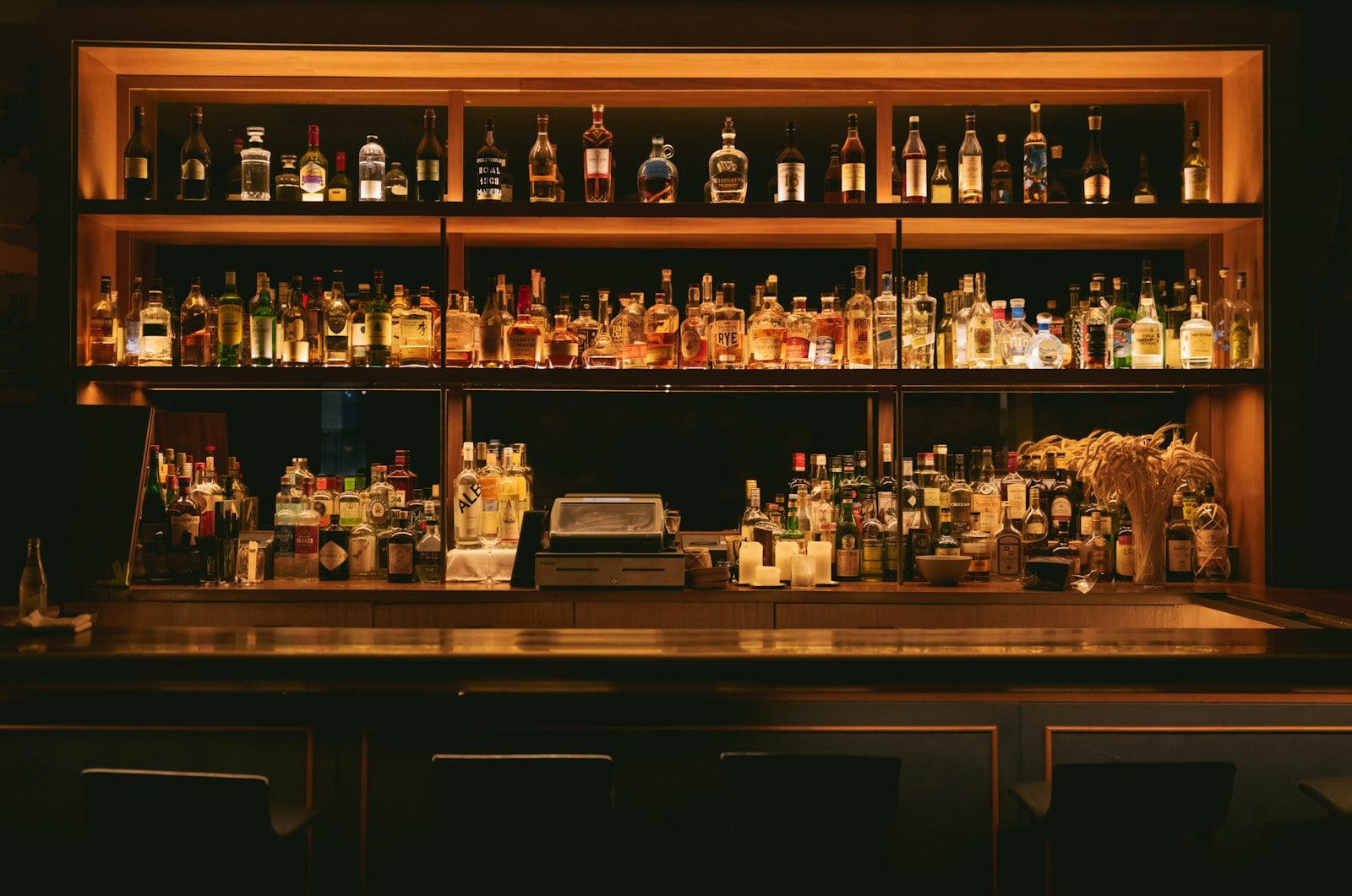 Bottles and glassware across a low-lit North Park bar